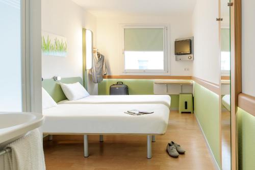 
a living room filled with furniture and a tub at ibis budget Ulm City in Ulm
