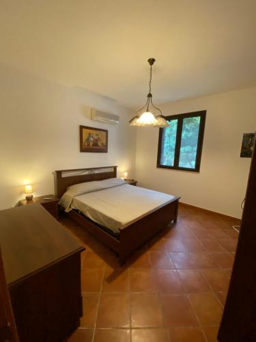 una camera con letto, tavolo e lampada di Il Villino a Cinisi