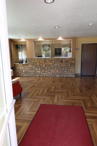 a large room with a fireplace and a red carpet at West Worth Inn & Suites White Settlement in White Settlement