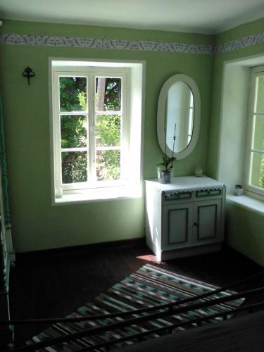 a green bathroom with a mirror and a sink at Traditional stone house in Pelion in Rodhiás