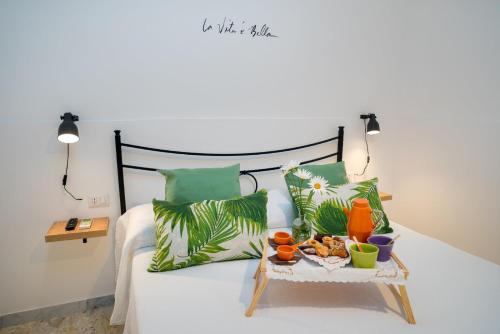 a bed with green pillows and a tray of food on it at La Zagara Holiday House - Cetara - Amalfi Coast in Cetara