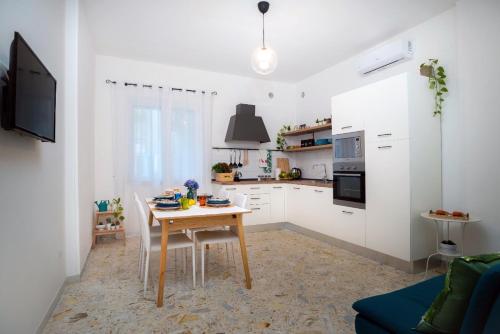 a kitchen with a wooden table and a kitchen with white cabinets at La Zagara Holiday House - Cetara - Amalfi Coast in Cetara