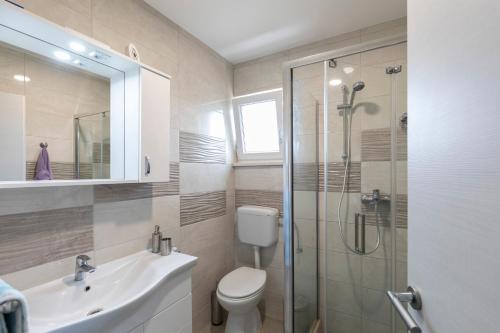 La salle de bains est pourvue d'une douche, de toilettes et d'un lavabo. dans l'établissement Villa Little Hill, à Postira