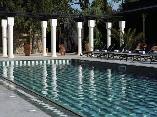 a swimming pool with lounge chairs next to a house at Esquisse Design Hotel in Tʼelavi