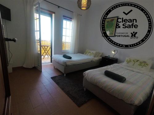 a room with two beds and a sign on the wall at Peniche Surf Lodge 2 in Peniche
