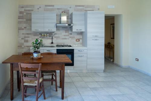 kuchnia z drewnianym stołem z krzesłami i kuchenką w obiekcie Mandevilla Home w mieście Caiazzo