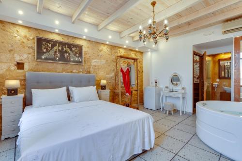 una camera con letto e vasca da bagno di Hamam Suites Portou a Chania