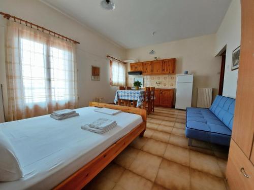 a bedroom with a large bed and a blue couch at Seaview- 2 Space - selfcatering Apartment - Helen No 3 in Xiropigado