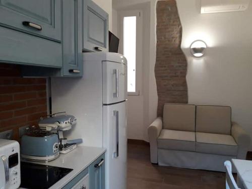 a kitchen with a white refrigerator and a couch at Via d'acqua Al Mulino -City Center- BO in Bologna