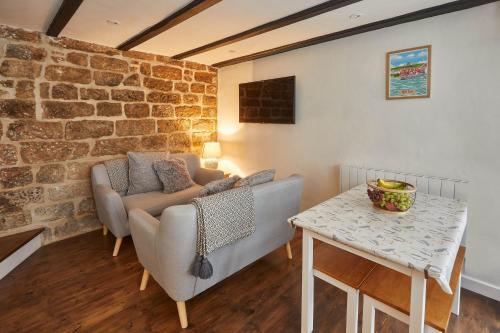 a living room with a couch and a table at Host & Stay - Dolphin Cottage 1736 in Whitby