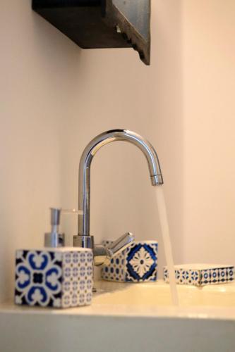 a sink with a faucet with water coming out at Aegean Blue Houses in Mandrakia