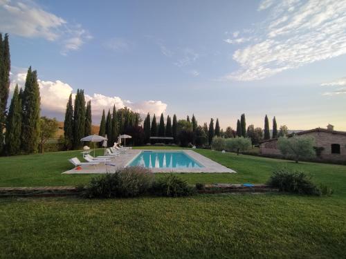 einen Pool im Garten mit Stühlen und Bäumen in der Unterkunft Agriturismo San Pierino in Monteroni dʼArbia