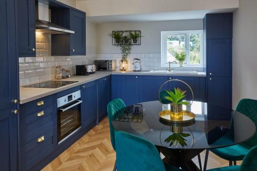 a kitchen with blue cabinets and a table and chairs at Host & Stay - Prospect Hill Apartments in Whitby