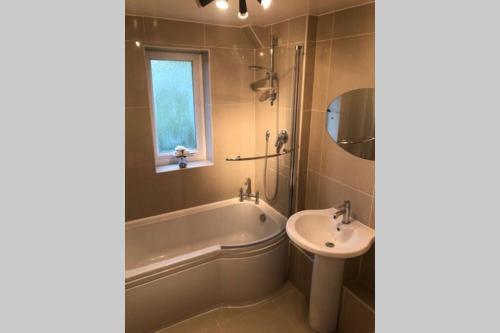 a bathroom with a bath tub and a sink at A Home Away from Home in Ipswich