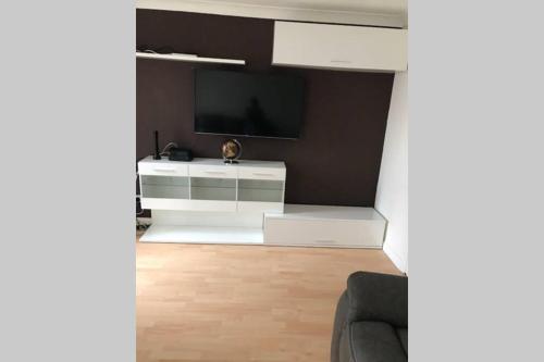 a living room with a tv and a white entertainment center at A Home Away from Home in Ipswich