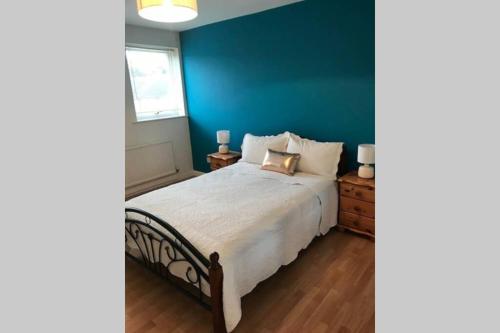 ein Schlafzimmer mit einem großen Bett mit blauer Wand in der Unterkunft A Home Away from Home in Ipswich