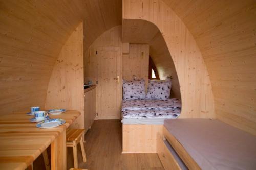 a room with a bed in a wooden house at Ferien im Naturwagen Pod 1 in Diedrichshagen