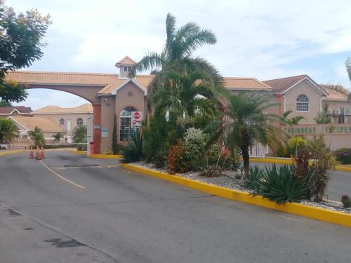 a building with palm trees in front of a street at Irie HideAway - Private Studio in Gated Community --Caribbean Estates, Portmore in Goshen Pen