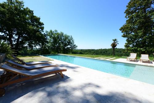 - une piscine bordée de chaises longues dans l'établissement Château du Grava, à Haux