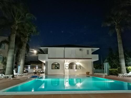 a swimming pool in front of a house at night at Villa Laura Residence Hotel Apartments & Studios in Ascea