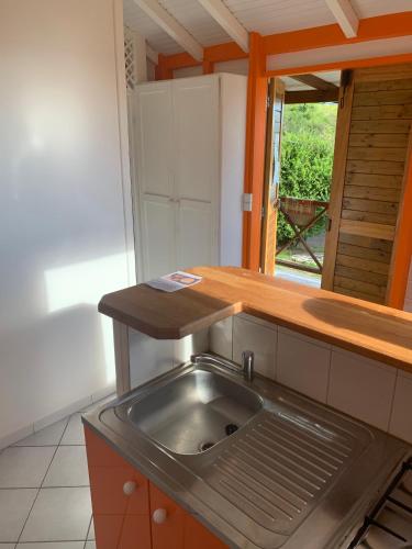 a kitchen with a sink and a wooden counter top at Bungalow les Cerisiers in Bouillante