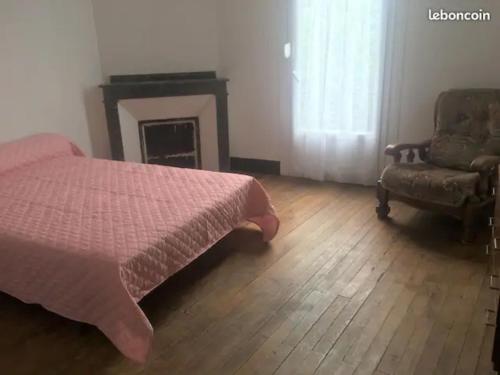 a bedroom with a bed and a fireplace and a chair at Gîte, maison de campagne à la ferme in Labarthe-Inard