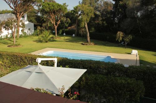 una sombrilla blanca sentada junto a una piscina en Apart. Barracuda, en Vilamoura