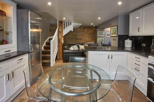 a kitchen with a glass table and a living room at Host & Stay - Brunswick Cottage in Staithes