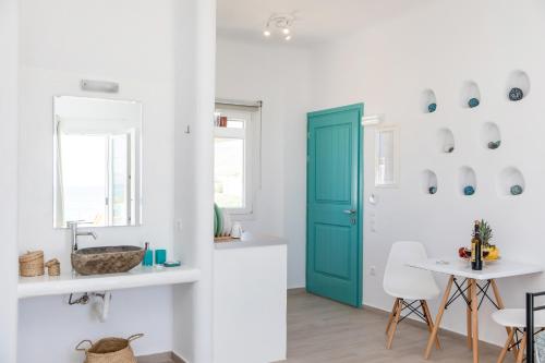 a kitchen with a blue door and a table at Elysium Beachfront Residences by kalais - A 10 Minute Drive Away From Naxos Town in Plaka