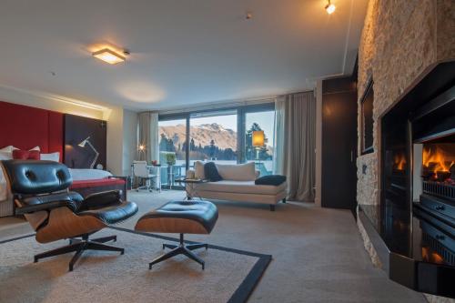 a living room with a fireplace and a living room with a couch at The Spire Hotel in Queenstown
