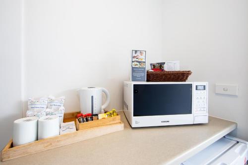 a microwave sitting on top of a table at New England Motor Lodge in Glen Innes