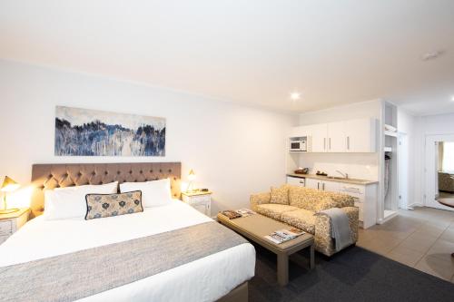 a bedroom with a bed and a couch at New England Motor Lodge in Glen Innes