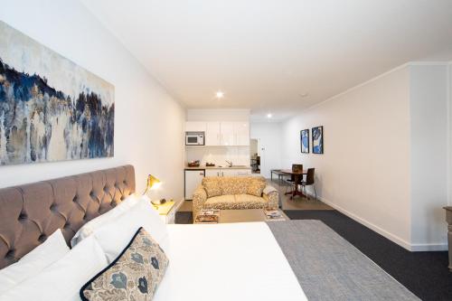 a bedroom with a large bed and a living room at New England Motor Lodge in Glen Innes