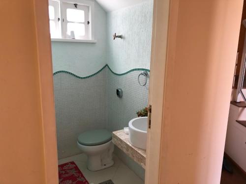 a bathroom with a toilet and a sink at Aconchegante casa com piscina e lazer completo in Teresópolis