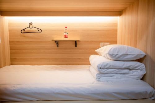 a room with a bed with a shelf and a bottle at Xi'an Desti Youth Park Hostel Bell & Drum Tower in Xi'an