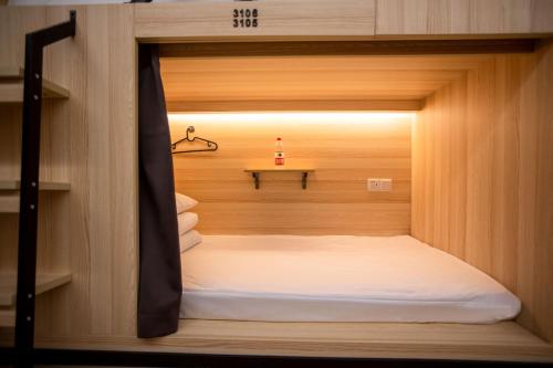 a small bed in a room with a small table at Xi'an Desti Youth Park Hostel Bell & Drum Tower in Xi'an