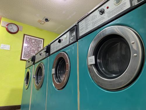 two washing machines in a laundry room with a clock at Tiki Lodge Hotel Modesto in Modesto