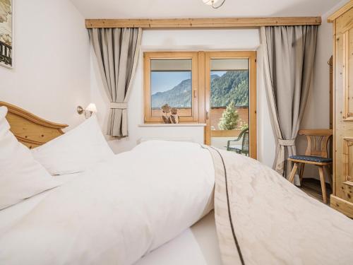 a bedroom with a large white bed and a window at Apart Garni Montana in Pertisau