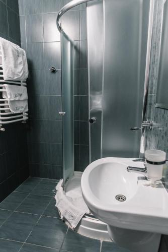 a bathroom with a shower and a white sink at Рестпарк рекреаційний комплекс in Luts'k