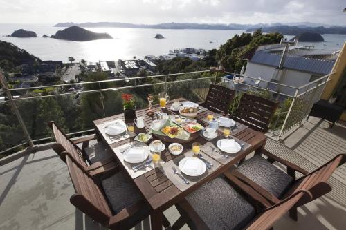 una mesa con platos de comida en la parte superior de un balcón en Allegra House en Paihia