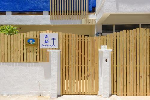 a wooden fence in front of a house at 夏天民宿 in Magong