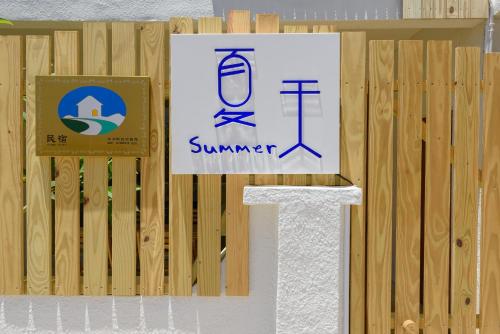 a wooden fence with a sign on it at 夏天民宿 in Magong