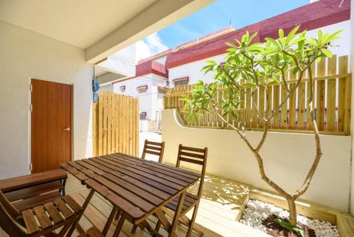 a wooden table and chairs on a balcony with a tree at 夏天民宿 in Magong