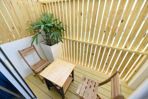 a balcony with two chairs and a bench and a plant at 夏天民宿 in Magong