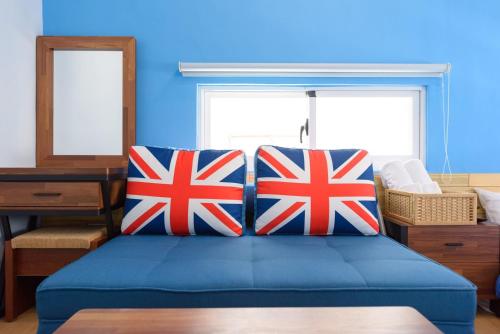 a blue bedroom with british flags pillows on a bed at 夏天民宿 in Magong
