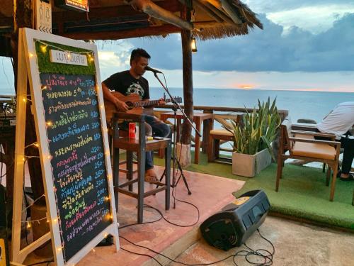 a man sitting in a bar playing a guitar at DD Hut Koh Tao in Koh Tao