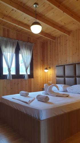 a large bed in a room with wooden walls at Villa Irida in Sarti