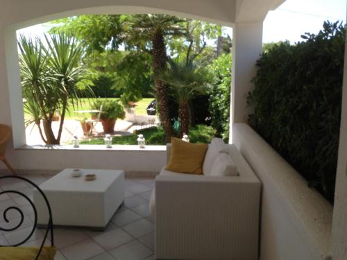 a patio with a couch and a table and trees at Villa Masai in Ostuni