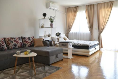 a living room with a couch and a bed at Luna apartman in Brčko