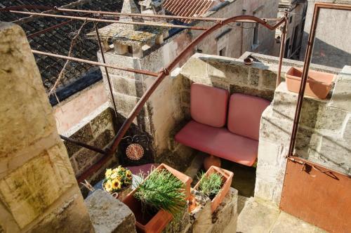 a stairs with a red chair and potted plants at Borgoterra in Martano